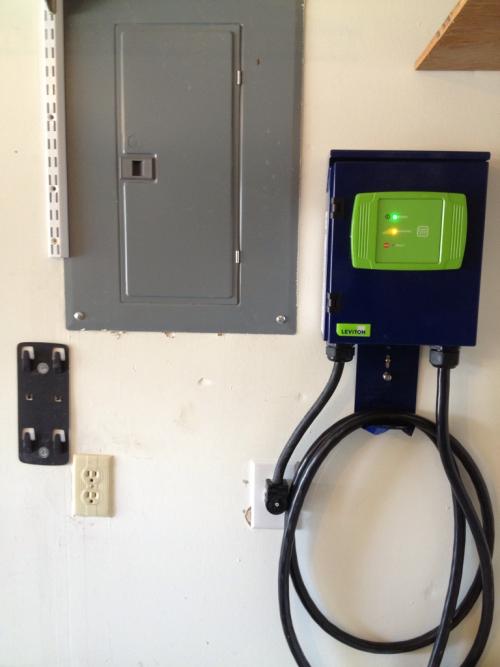 electric vehicle charger plugged in near a breaker box